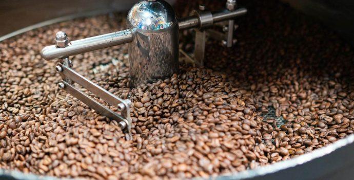 Kaffebønner i en professionel ristemaskine under risteprocessen, hvor varme og bevægelse udvikler smagsnuancerne.